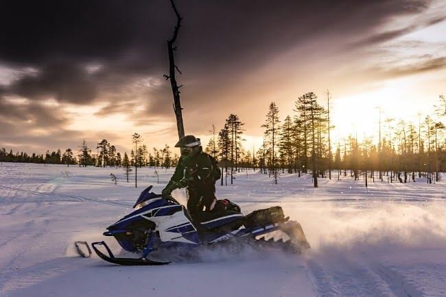 Snowmobile at dusk on a frozen lake.