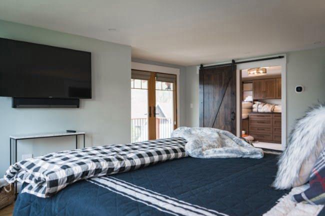 Master Suite 1 with king bed, smart TV, and barn door to the ensuite.