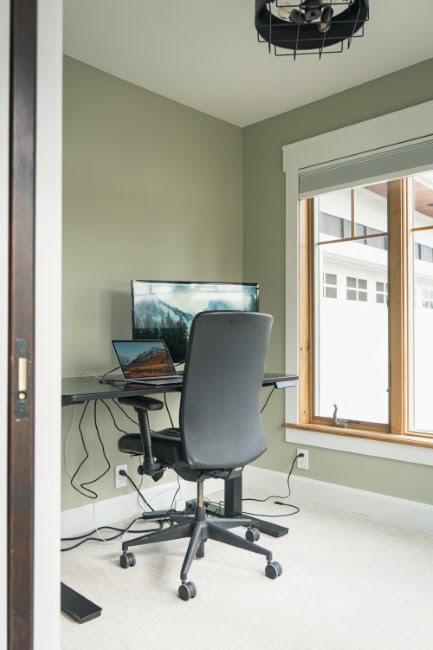 Home office with desk, monitor, and lake views.